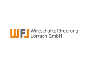 Logo der Wirtschaftsförderung Lörrach GmbH mit orangenen und grauen Buchstaben auf weißem Hintergrund.