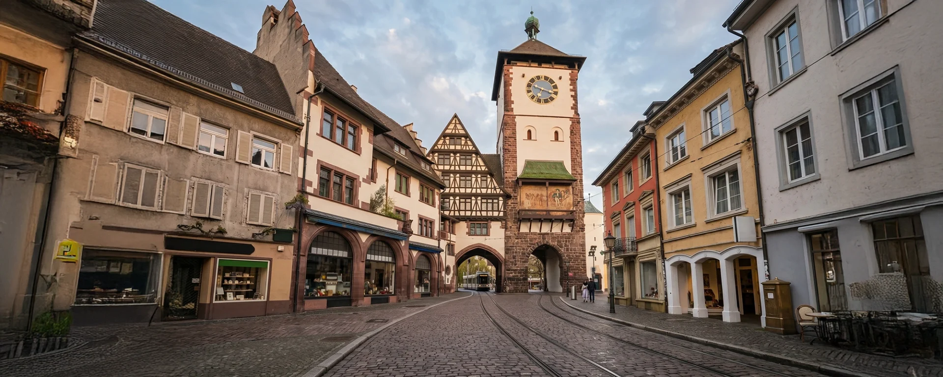 Historisches Martinstor in Freiburger Altstadt mit Fachwerkhäusern und Kopfsteinpflasterstraße als Visualisierung für Google Ads aus Freiburg.
